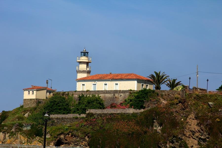 Faro de Cudillero sobre el acantilado, a la salida del puerto